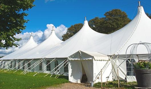 tall green portable restrooms assembled at a music festival, contributing to an organized and sanitary environment for guests in Avon